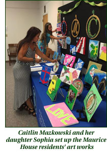 Caitlin an Sophia Mazkowski set up Maurice House residents' artwork